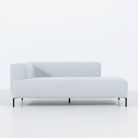 NOYES Fader Standardのカウチソファ。淡いグレーのファブリックで包まれた、全ての部位に丸みを持たせた有機的なフォルム。ひじと背が外側に張り出した浮遊感のある座面を、細身の黒いスチール脚が支える軽やかな意匠設計。